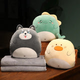 Three plush animal pillows in gray, green, and yellow, with two gray travel blankets stacked underneath.