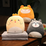 Three plush animal pillows in yellow, orange, and gray, with two soft gray blankets stacked underneath.