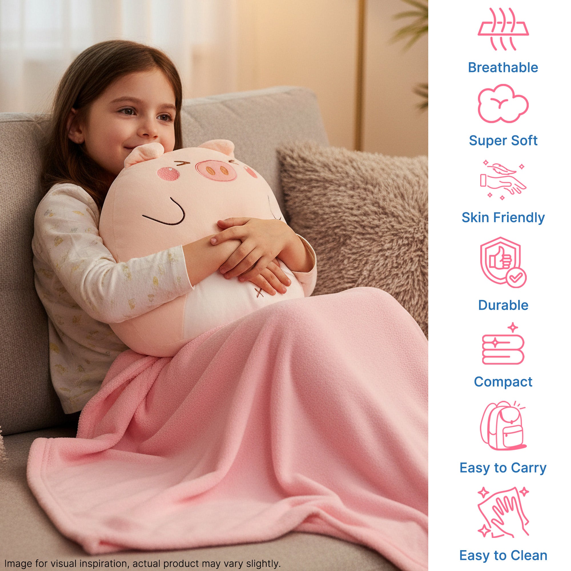 A child sits on a couch, hugging a plush pig pillow while wrapped in a pink blanket.