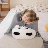 Child sleeping on a panda-shaped pillow with a gray blanket.