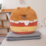 Plush pillow shaped like a bear with a colorful layered design, resting on folded gray blankets.