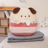 A plush pillow shaped like a dog sits on top of two folded gray blankets in a cozy room setting.