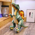 Lifelike Spinosaurus plush pillow with vibrant colors, standing on a wooden floor with art in the background.
